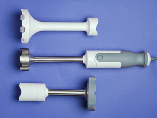 Electric hand blender with nozzles on a purple background. Top view, Flat lay
