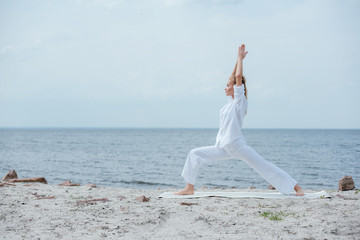 side view of blonde woman practicing yoga near river