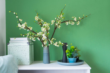 beautiful flower in a vase on green wall in living corner at home