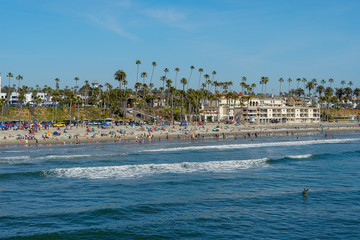 People on the beach enjoying beautiful spring day at Oceanside beach in San Diego, California. 