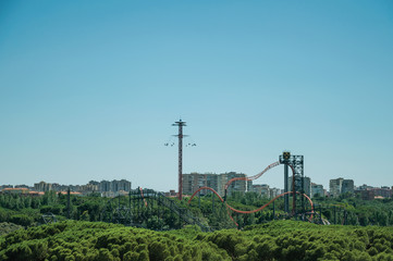 Roller coaster in amusement park and trees in Madrid