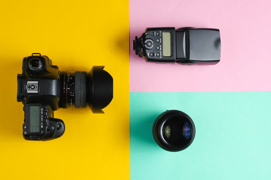 Camera, flash, lens on colored pastel background. Equipment photographer. Top view. Minimalism