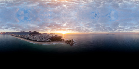 Fototapeta na wymiar 360 degree aerial panorama of Rio de Janeiro seen from just off the coast of the Arpoador rock with the wider cityscape in the background at sunrise ready for use in 3D environment mapping and 360VR.