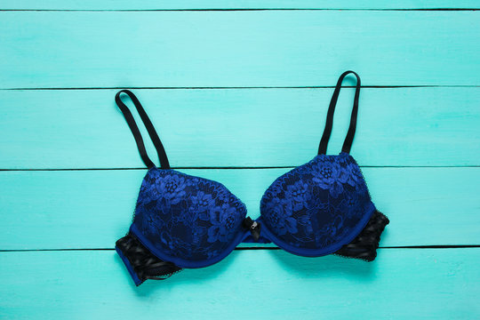 Female bra on a blue wooden background. Top view