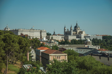 Fototapeta na wymiar Royal Palace and Almudena Cathedral with buildings among trees in Madrid