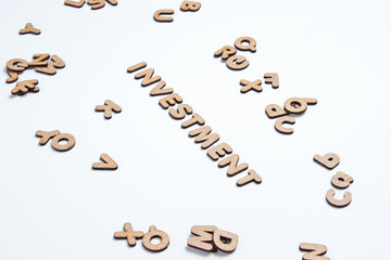 Word investment from wooden letters on a white background.