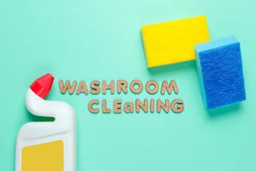 Bottle toilet wash gel and sponge on a blue background with the words washroom cleaning. Top view