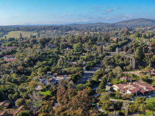 Obraz premium Aerial view of wealthy countryside area with luxury villas with swimming pool, surrounded by forest and mountain valley. Ranch Santa Fe. San Diego, California, USA.
