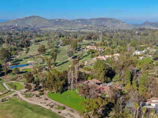 Aerial view of wealthy countryside area with luxury villas with swimming pool, surrounded by forest...