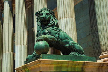Sculpture lion cast in bronze on building facade in Madrid