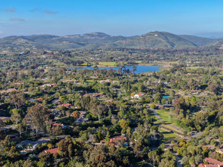 Fototapeta na wymiar Aerial view of wealthy countryside area with luxury villas with swimming pool, surrounded by forest and mountain valley. Ranch Santa Fe. San Diego, California, USA.
