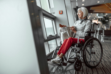 Mature lady on disabled carriage waiting at airport