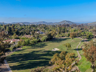 Fototapeta na wymiar Aerial view of a beautiful wealthy green golf course next the valley. San Diego, California. USA.