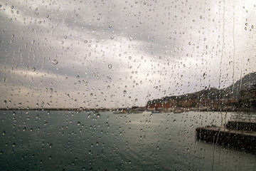 View of the harbor of Santa Margherita Ligure from the window of a boat with raindrops on the glass in a rainy day, Genoa, Liguria, Italy