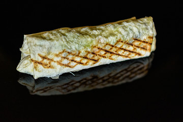 Shawarma with chicken and cabbage on a dark background.