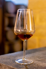 Tasting of fortified dry or sweet marsala wine in vintage wine cellar with old oak barrels in Marsala, Sicily, Italy