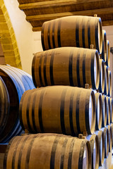 Vintage wine cellar with old oak barrels, production of fortified dry or sweet marsala wine in Marsala, Sicily, Italy