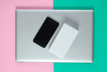 The concept of unboxing, techno blogging. Box with a new smartphone, laptop on pastel background.
