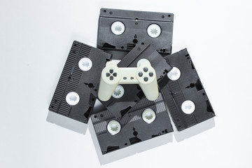 Gamepad on retro video cassettes. Minimalism studio shot on white background