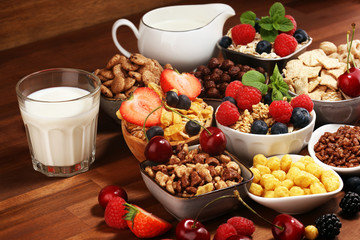 Cereal. Bowls of various cereals, berries and milk for breakfast. Muesli with kids cereals.