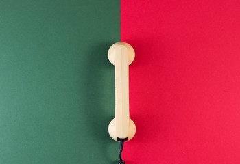 Handset of a retro phone on a red-green background. Top view