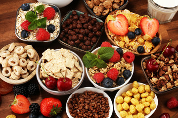 Cereal. Bowls of various cereals, berries and milk for breakfast. Muesli with kids cereals.