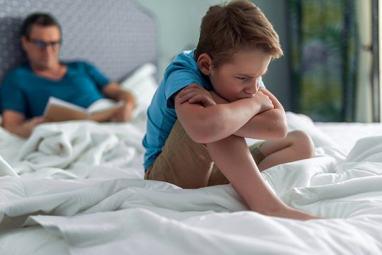 Upset Boy Sitting On The Edge Of The Bed