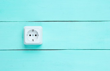 Power socket on blue wooden wall, minimalism