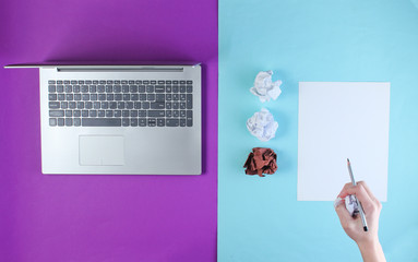 Obraz premium Workspace. Minimalistic business concept. Notebook, crumpled balls of paper, hand write on sheet of paper with pencil on blue-purple background. Top view