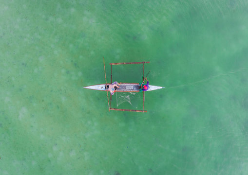 Aerial view of couple fishing and traditional filipino boat, Dauis, Philippines.