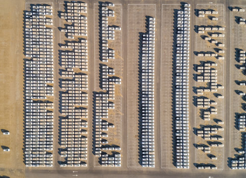 Faraway aerial view of group of cars at parking space on a desert landscape.