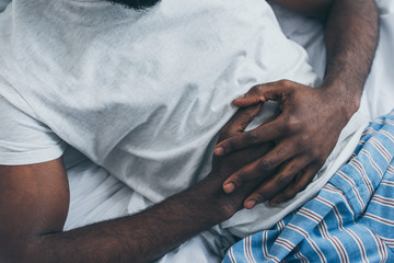 cropped view of african american man suffering from abdominal pain