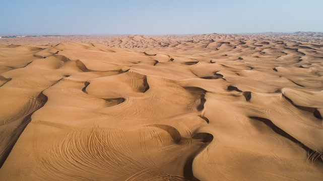 Aerial view of people driving quad bikes in the sand dunes of Al Bedayer desert in Sharjah, U.A.E.