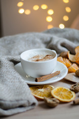 Cup of coffe on the table and garland lights on background