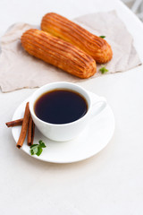 Fragrant coffee with eclairs in the summer cafe.