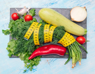 Measuring tape for measuring circumference. Vegetables for diet cooking.