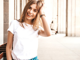 Portrait of beautiful smiling blond model dressed in summer hipster clothes. Trendy girl posing in the street background. Funny and positive woman having fun