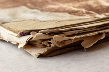 Old book on white surface. Disheveled book. A worn-out book on a white surface. A worn-out book on a white background