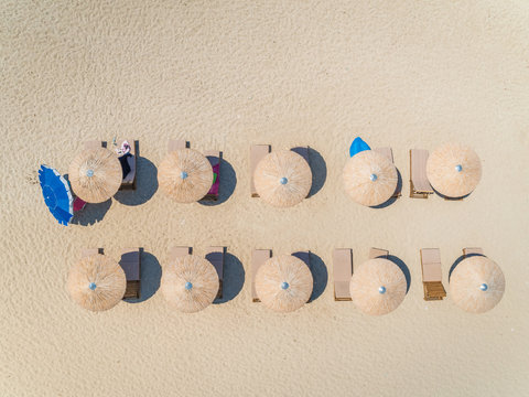 Aerial view above of beach with straw parasols on Lefkada, Greece.