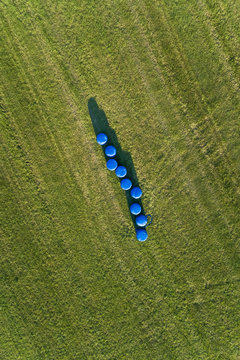 Aerial view of hay envolve in plastic in the middle of agricultural fields.