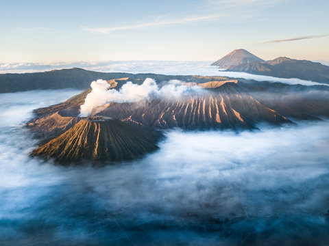 Aerial view of the active Volcano Bromo through clouds and smoke in Indonesia.
