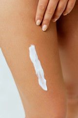 Closeup  on cream on smooth tanned legs. Woman applying Moisturizing lotion on skin.  Protection cream.
