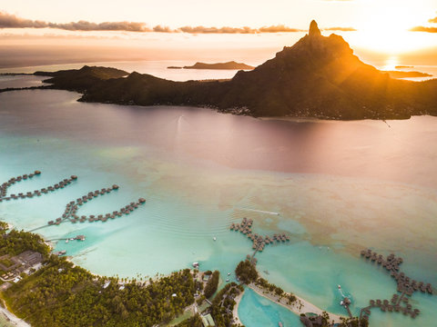 Aerial view of Bora Bora with red sunset light on Mount Otemanu in French Polynesia.