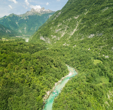 Aerial view of Soca river surrounded by hills and forest with nature in Slovenia
