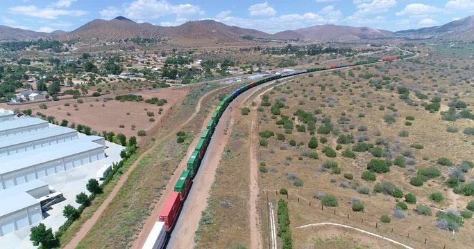 Drone 4K video of a long locomotive going through the mountains in Acton California	
