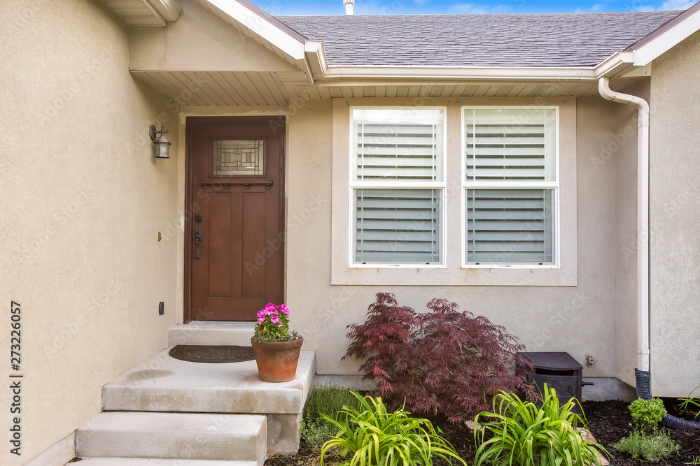 Wall mural facade of a house with concrete stairs that leads to the glass paned brown door