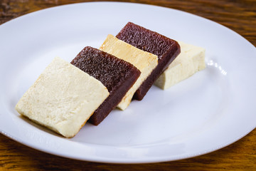 Brazilian dessert known as Romeo and Juliet. Sliced ​​cheese with pieces of guava on white plate.