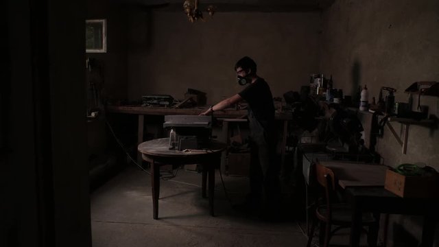 The craftman is working on electric saw machine. Sawing a large wooden board.