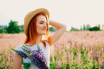 Young woman with red hair walking in the field