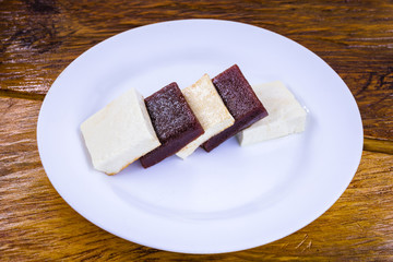 Brazilian dessert known as Romeo and Juliet. Sliced ​​cheese with pieces of guava on white plate.